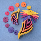 A flatlay using the large and small Grimms wooden fire sets with buttons and triangular loose pieces