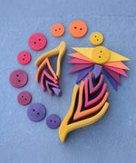 A flatlay using the large and small Grimms wooden fire sets with buttons and triangular loose pieces