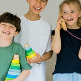 Children holding a small and large Grimms neon green conical stacking towers