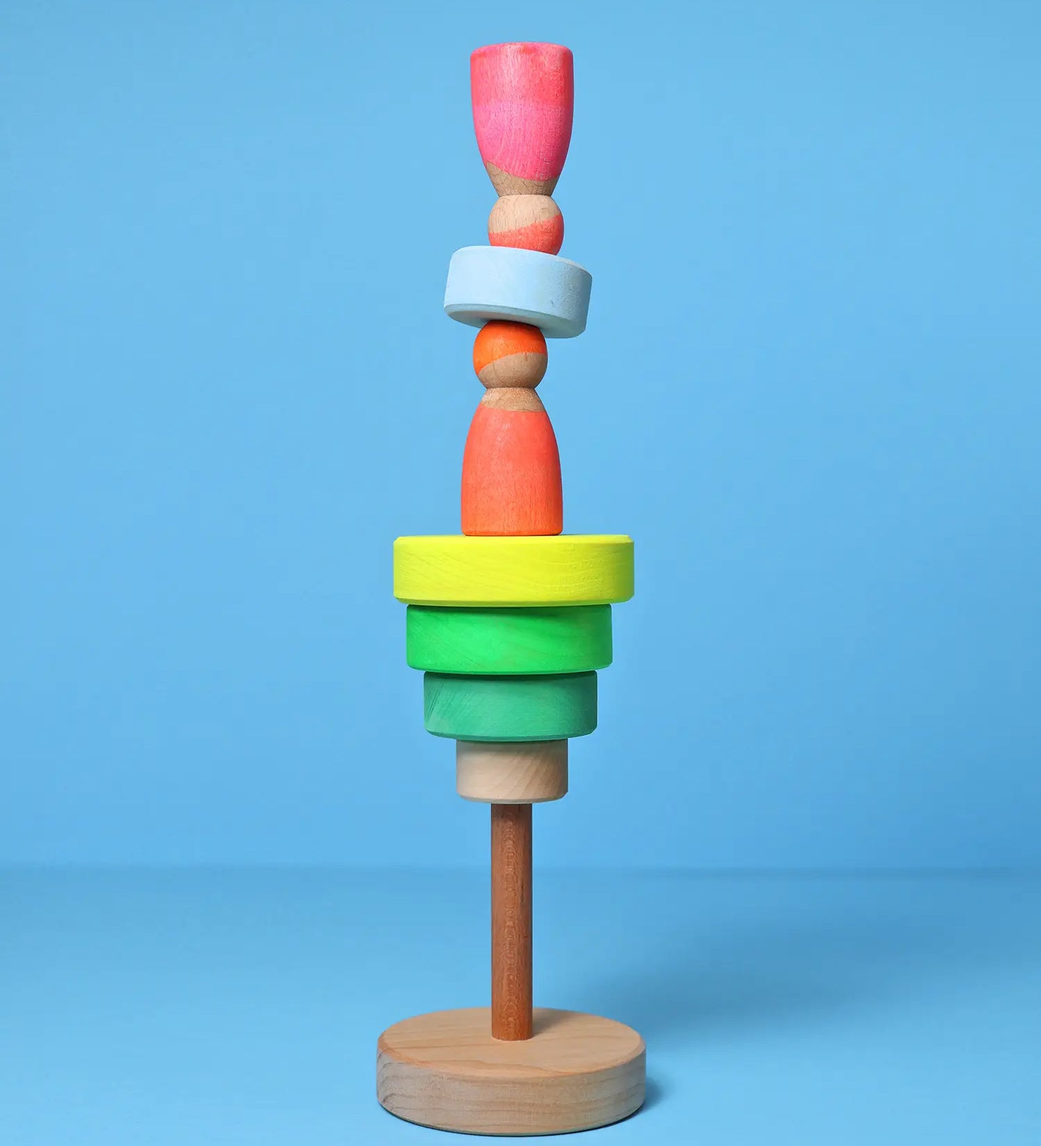 Loose small Grimms neon green conical pieces stacked with neon peg dolls balancing on top