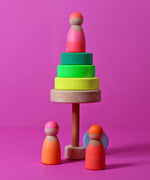 A tree made from loose wooden neon green Grimms conical tower pieces with a peg doll on top