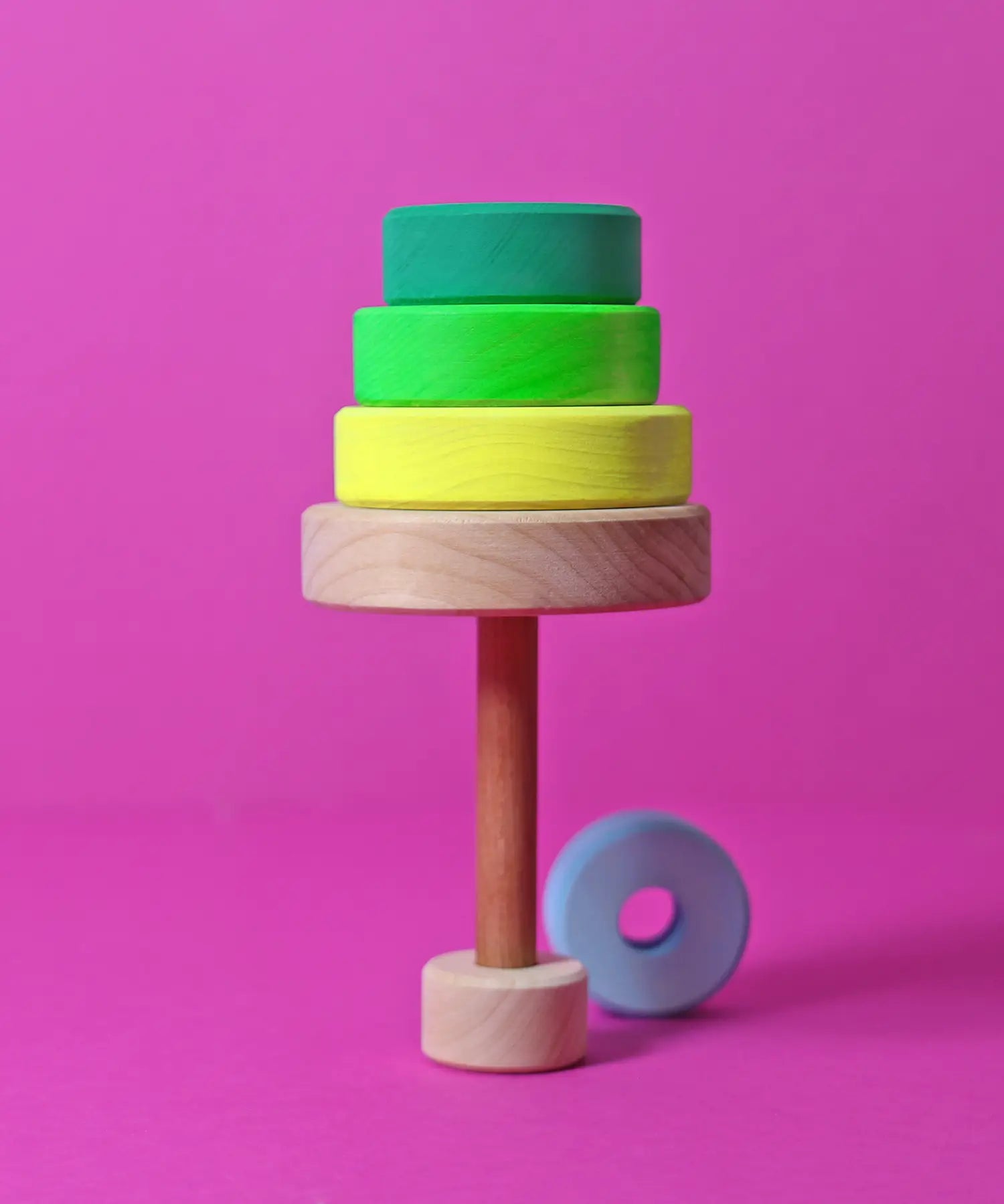 A tree made from loose handcrafted wooden neon green Grimms conical tower pieces
