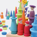Open ended play set up using Grimms small stacking rollers, rings, coins and other loose blocks in a rainbow palette