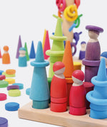 Open ended play set up using Grimms small stacking rollers, rings, coins and other loose blocks in a rainbow palette