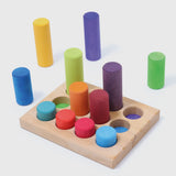 Loose Grimm's small building rollers in a rainbow palette next to a wooden sorting tray.
