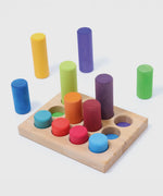 Loose Grimm's small building rollers in a rainbow palette next to a wooden sorting tray.