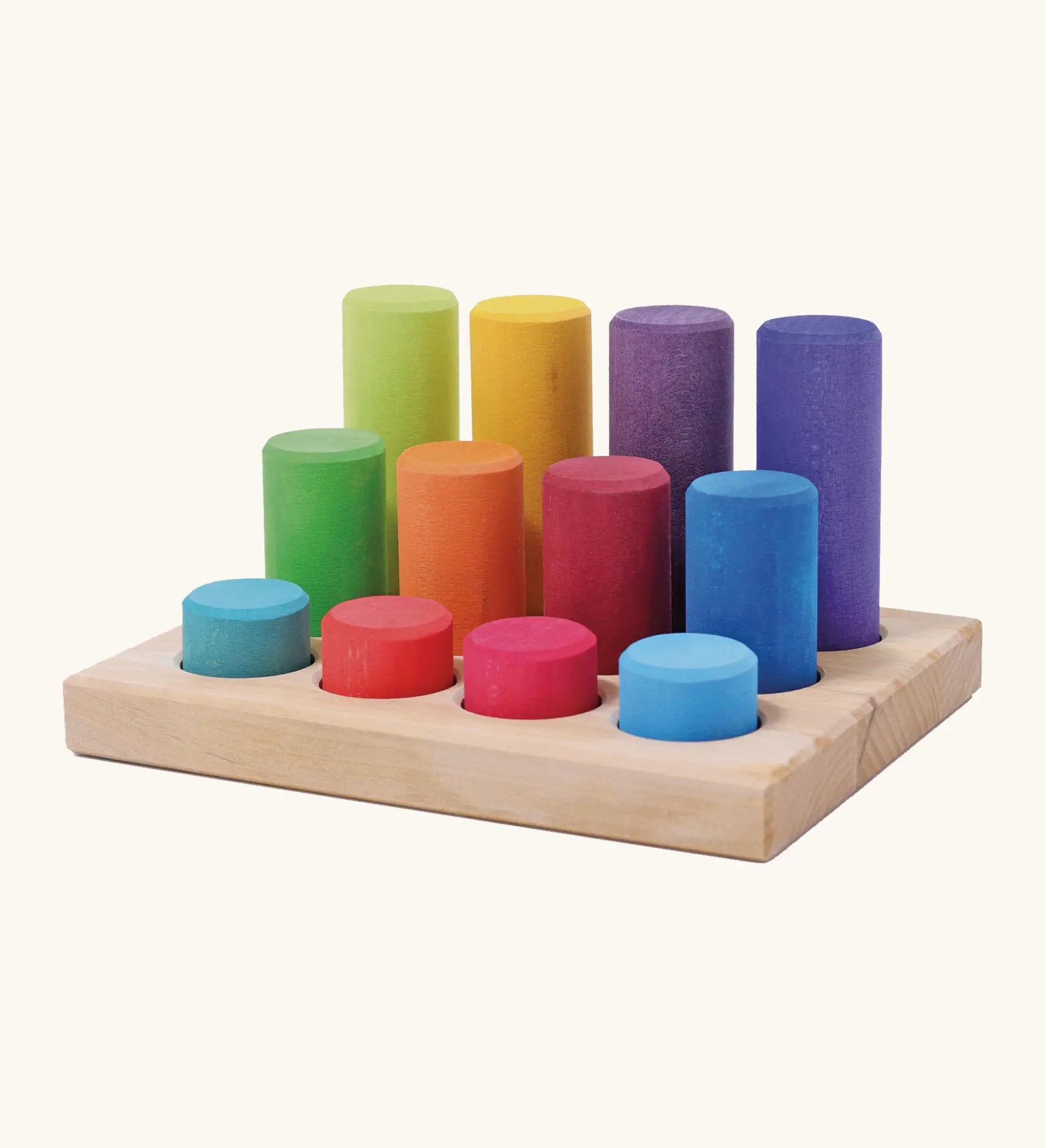Grimm's small building rollers in bright rainbow colours in a wooden storage tray.