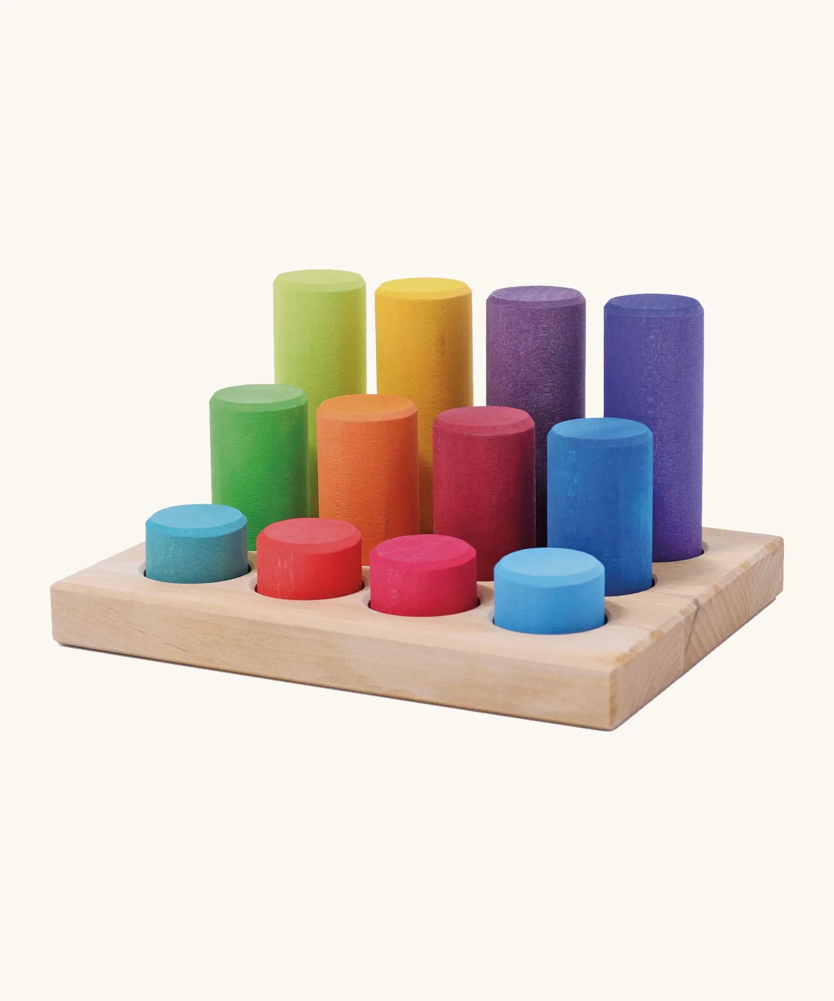 Grimm's small building rollers in bright rainbow colours in a wooden storage tray.