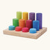 Grimm's small building rollers in bright rainbow colours in a wooden storage tray.