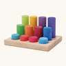 Grimm's small building rollers in bright rainbow colours in a wooden storage tray.