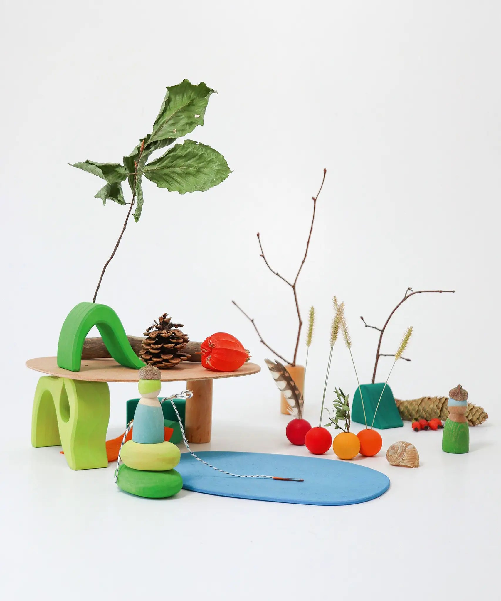 A display showing loose blocks from the Grimms small world play in the woods, peg dolls and woodland pieces