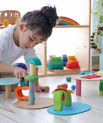 Child playing with the Grimm's small world play in the woods set with other popular building blocks