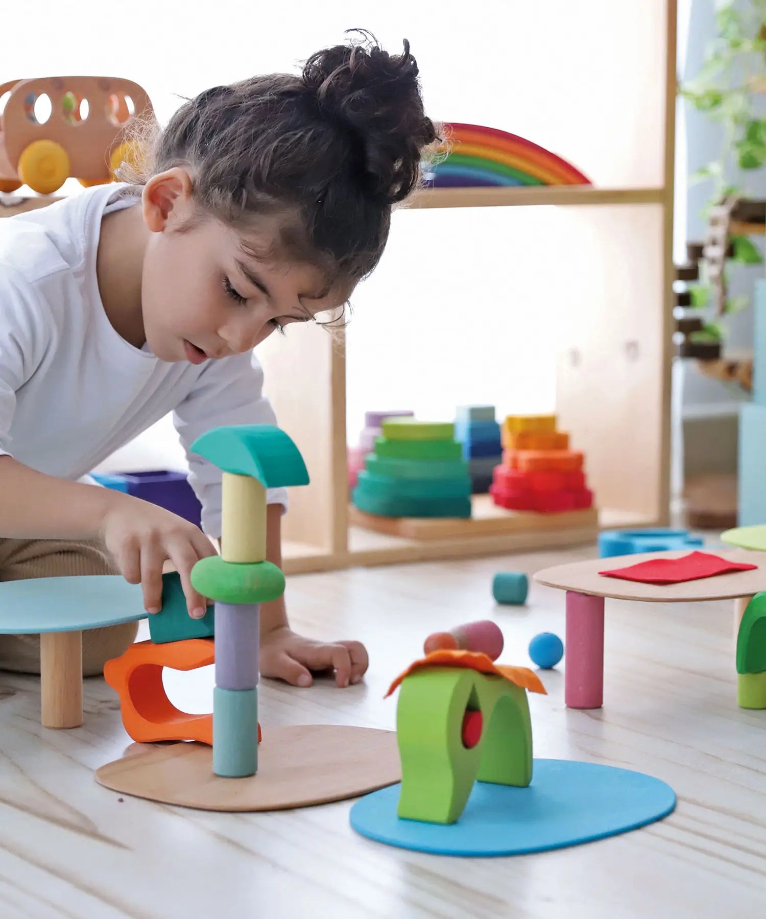 Child playing with the Grimm's small world play in the woods set with other popular building blocks