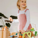 Child playing with the Grimms handcrafted wooden small world play in the woods set