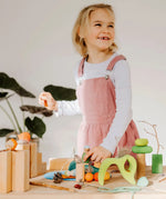 Child playing with the Grimms handcrafted wooden small world play in the woods set