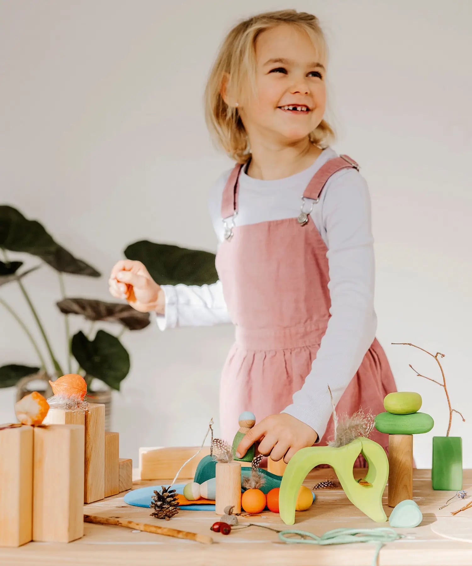 Child playing with the Grimms handcrafted wooden small world play in the woods set