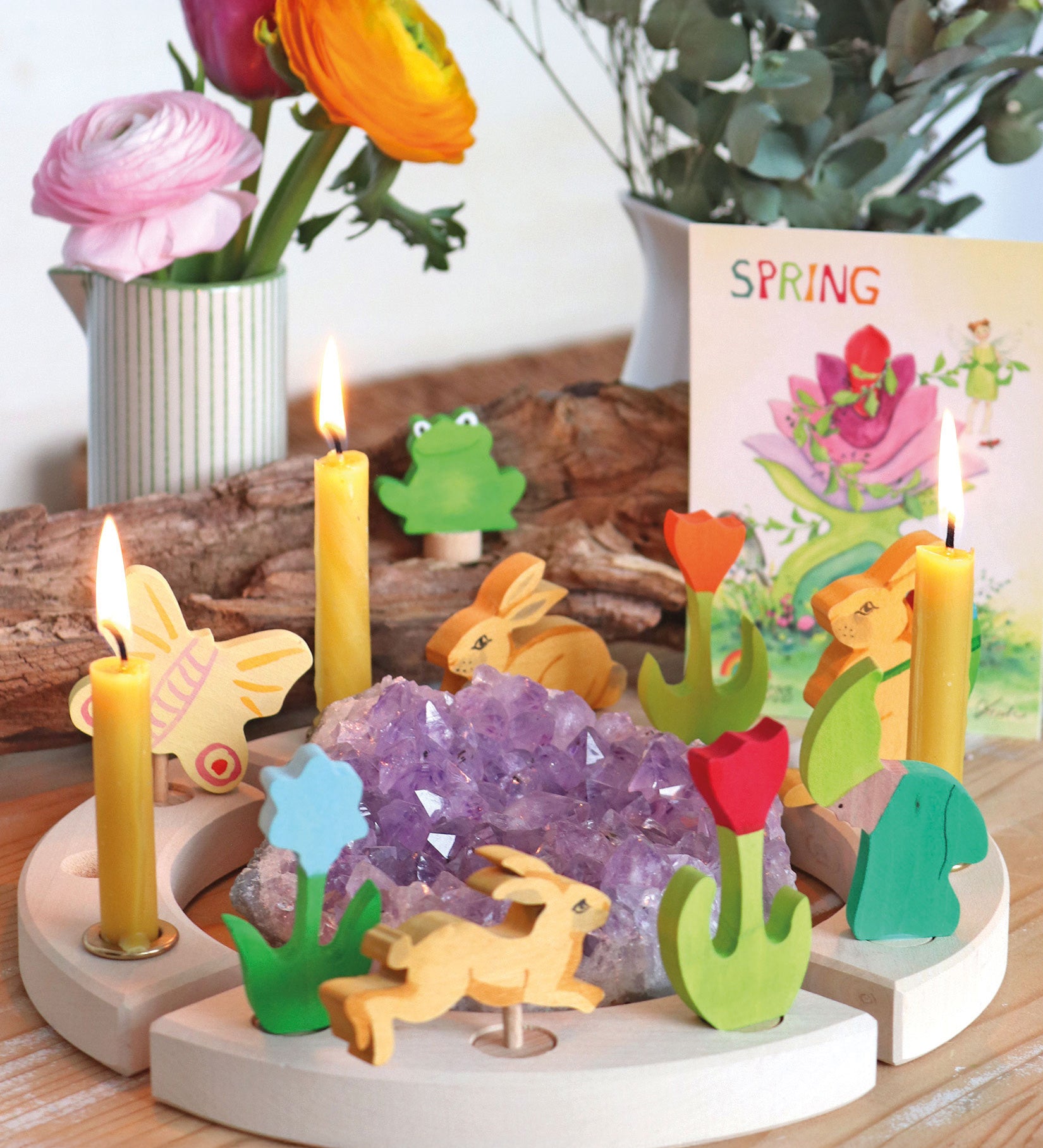 A spring themed display showing the different wooden Grimms decorative figure and candles on the decorative ring