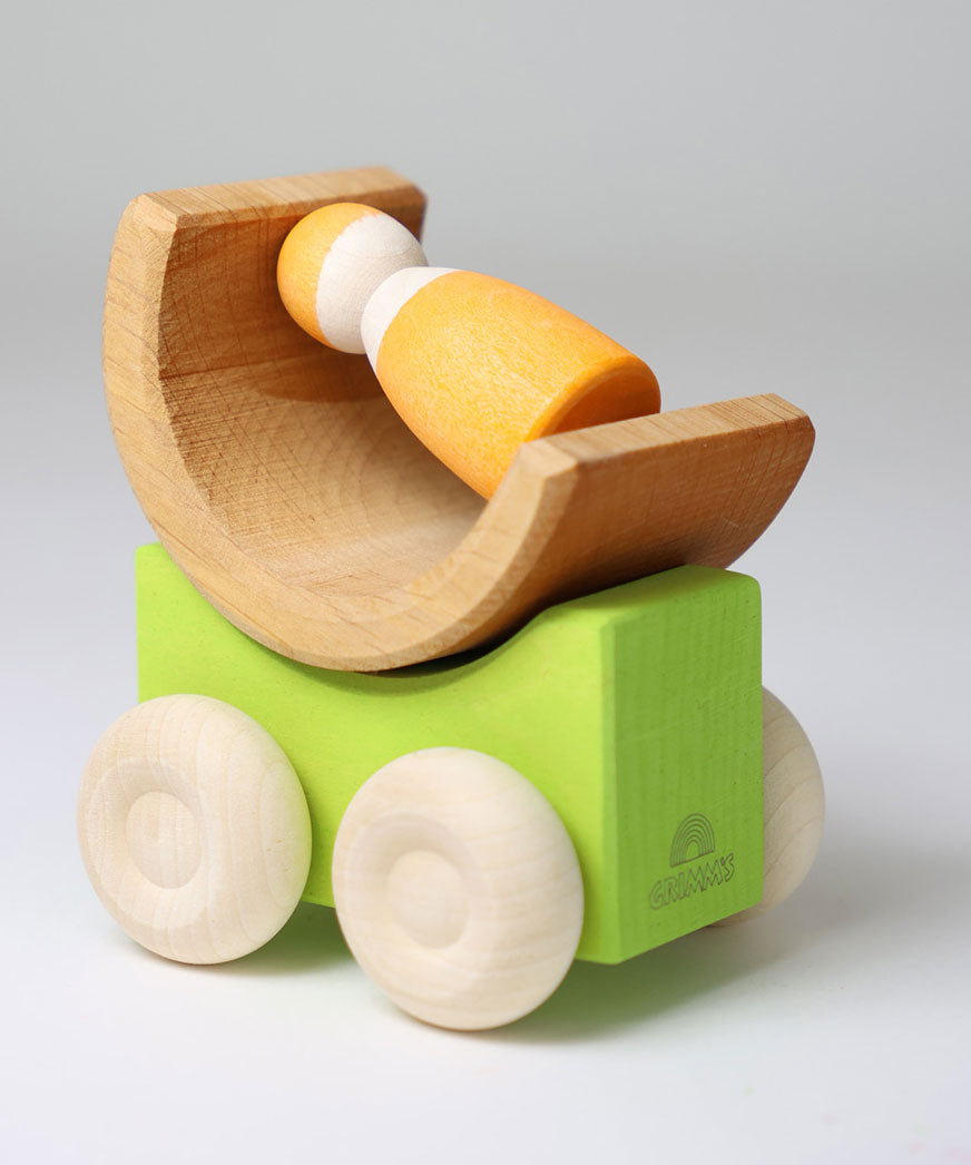 A green Grimm's stacking car with a mini rainbow piece and Grimm's friend wooden peg doll placed on top of it. These Grimm's toys are part of a wide range of wooden toys available here at Babipur. 