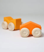 A set of two Grimm's orange wooden toy cars that can be stacked on top of each other. These Grimm's toys are part of a wide range of wooden toys available here at Babipur. 
