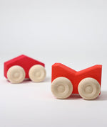 A set of two Grimm's red wooden toy cars that can be stacked on top of each other. These Grimm's toys are part of a wide range of wooden toys available here at Babipur. 