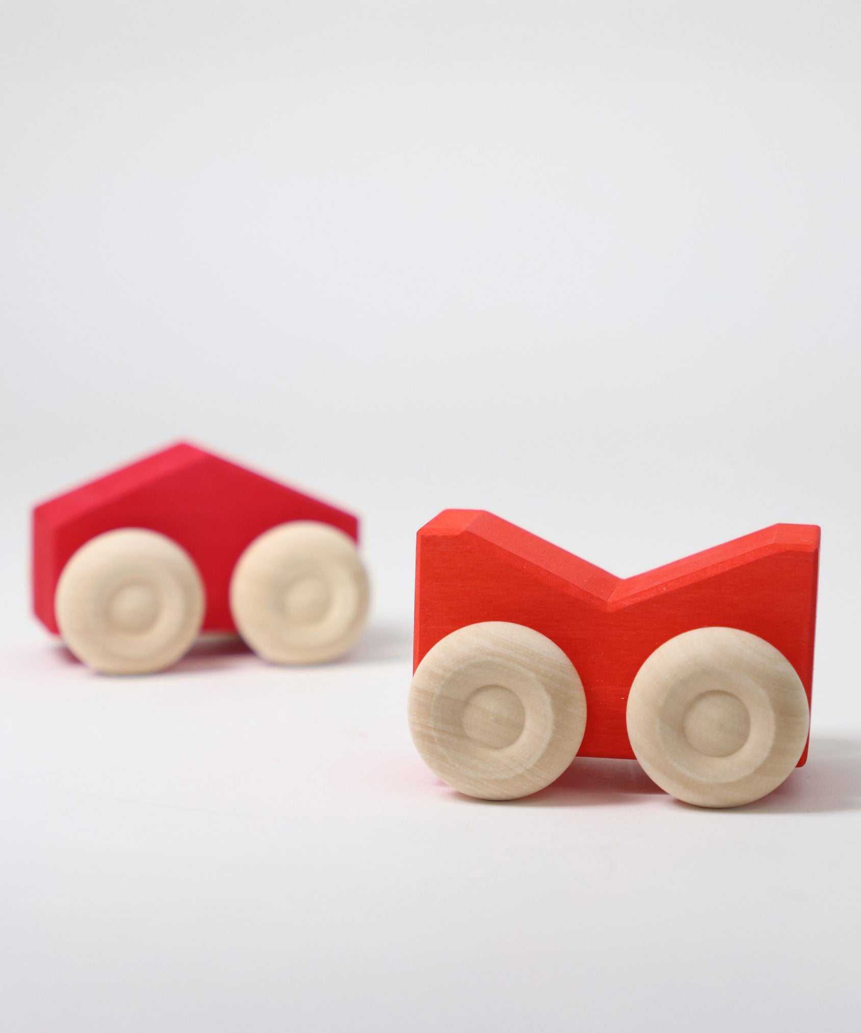 A set of two Grimm's red wooden toy cars that can be stacked on top of each other. These Grimm's toys are part of a wide range of wooden toys available here at Babipur. 