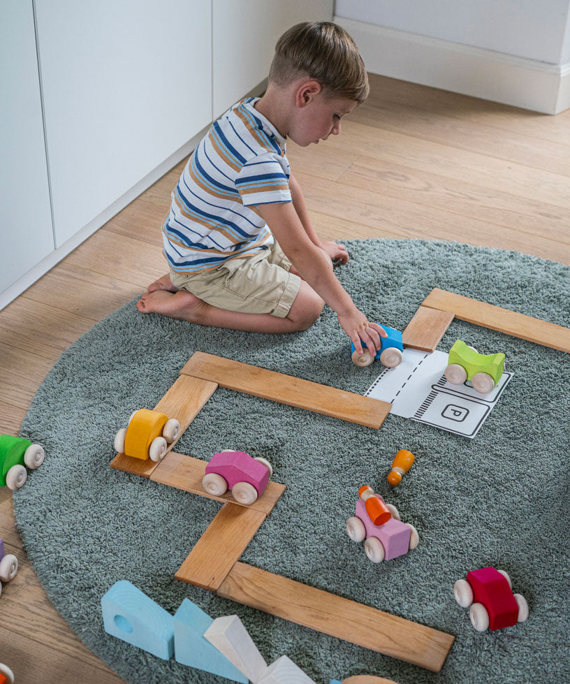 A child playing with the Grimm's Stacking Cars and building boards. Wooden toy cars that comes in a two back that can can be stacked on top of each other.
These Grimm's toys are part of a wide range of wooden toys available here at Babipur. 