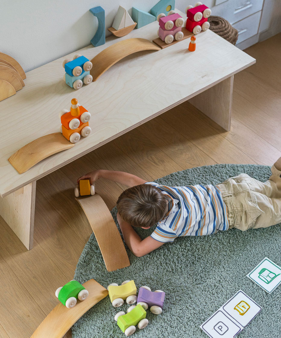 A child playing with the Grimm's Stacking Cars and the Grimm's natural bridges. Wooden toy cars that comes in a two back that can can be stacked on top of each other.
These Grimm's toys are part of a wide range of wooden toys available here at Babipur. 