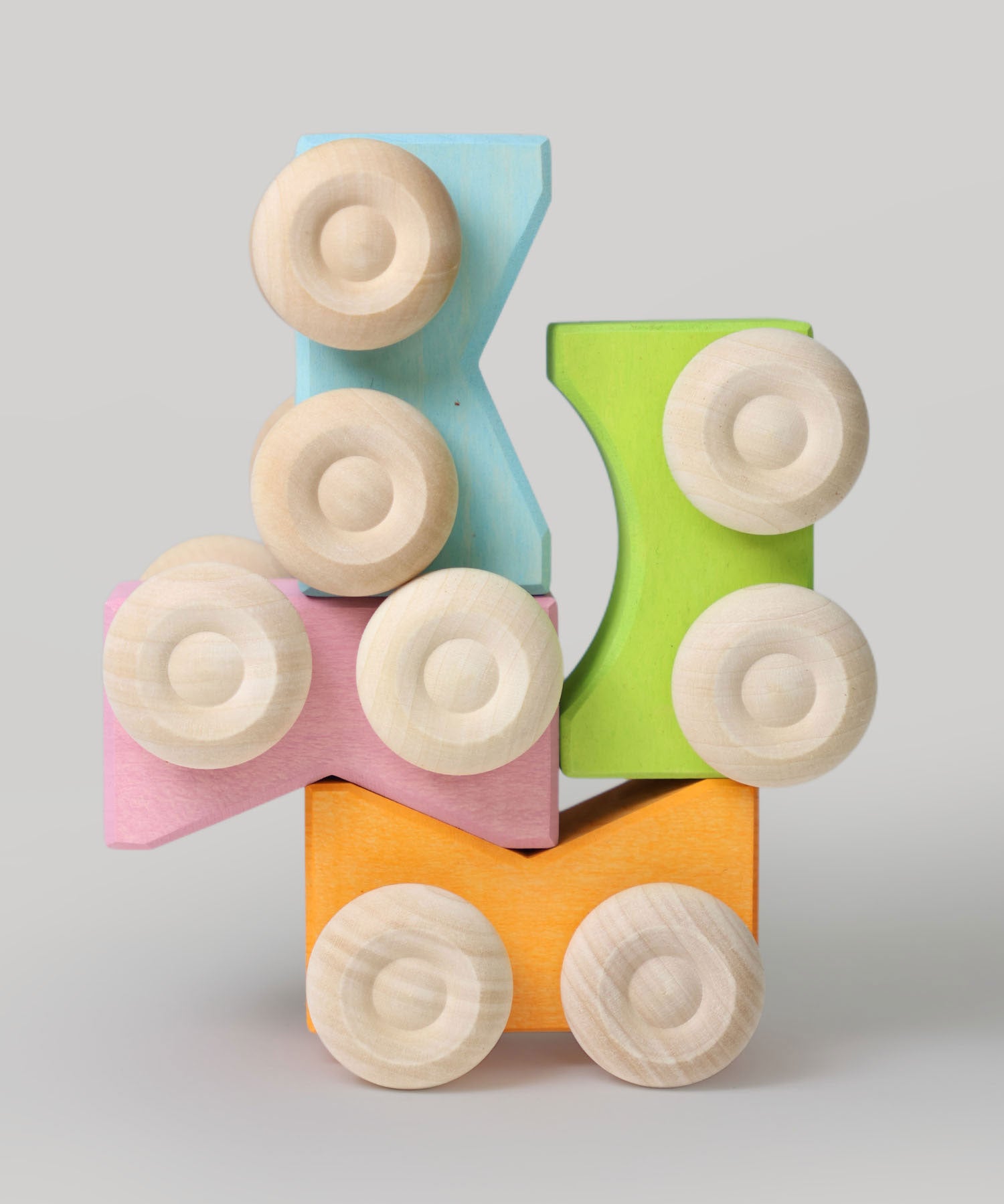 Four Grimm's stacking cars in pastel coloured shades stacked on top of each other. These Grimm's toys are part of a wide range of wooden toys available here at Babipur. 