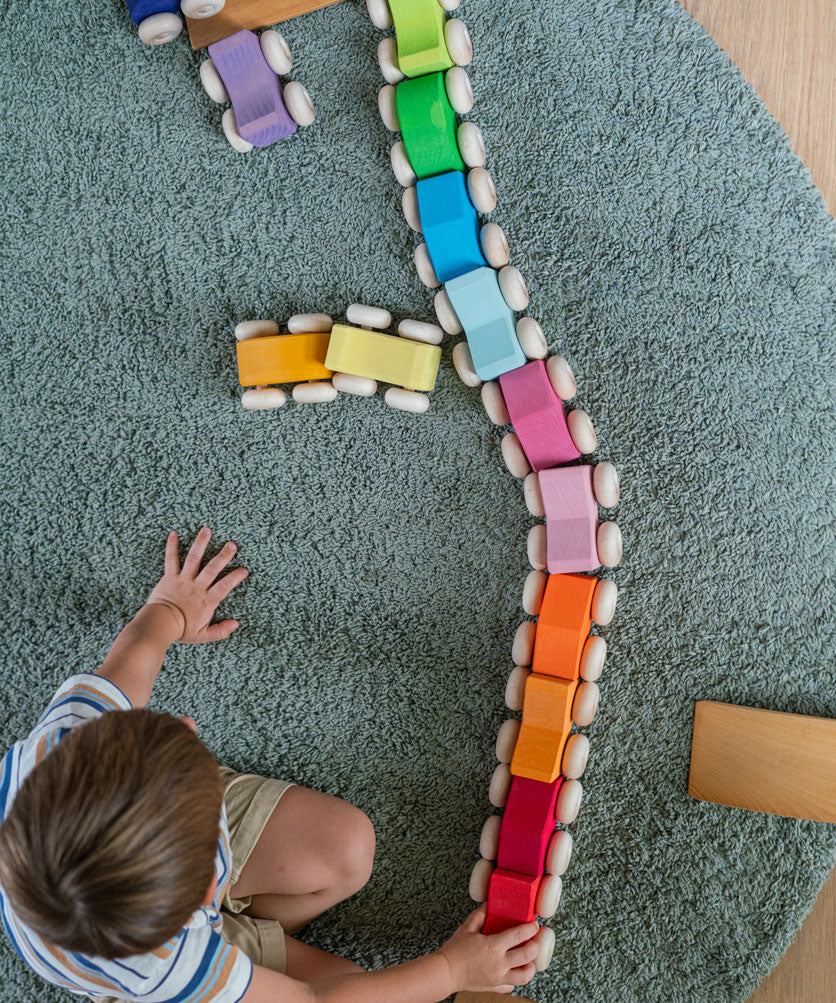 A child playing with the Grimm's Stacking Cars lining them all up on a rug. Wooden toy cars that comes in a two back that can can be stacked on top of each other.
These Grimm's toys are part of a wide range of wooden toys available here at Babipur. 