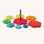 Grimm's Stacking rainbow Flowers Tower on a plain background. The pieces have taken off the base piece and laid out around it. 