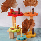 Grimm's Stacking Flowers Tower with two flowers used to hold Grimm's candles as part of an Autumnal seasonal display. Some of the flower pieces have been decorated with leaves and Grapat Nins.