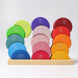 Grimms wooden stacking moon shapes houses on the tray with one stack leaning