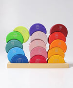 Grimms wooden stacking moon shapes houses on the tray with one stack leaning