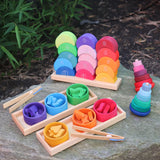 Grimms wooden stacking moon shapes houses displayed on a rock with a shape sorter set and 2 wobbly towers