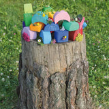 Looose Grimms wooden stacking moon shaped house pieces displayed on a tree stump