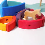 Pieces from the Grimm's Stacking Tower Boat used to create little enclosures or fields for wooden toy animals. A wooden horse has been placed in one. 