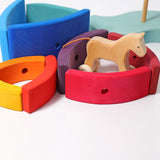 Pieces from the Grimm's Stacking Tower Boat used to create little enclosures or fields for wooden toy animals. A wooden horse has been placed in one. 