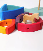 Pieces from the Grimm's Stacking Tower Boat used to create little enclosures or fields for wooden toy animals. A wooden horse has been placed in one. 