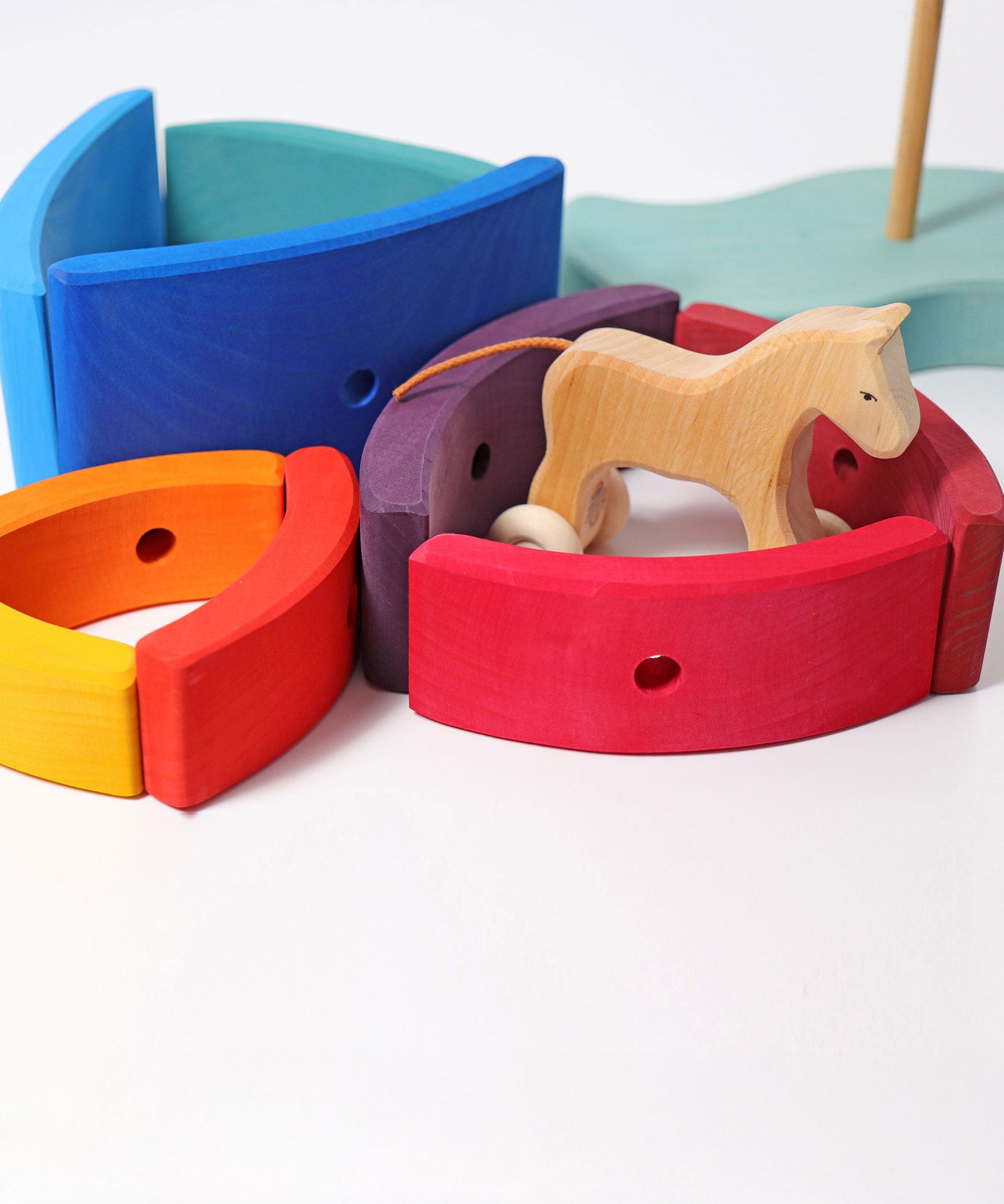 Pieces from the Grimm's Stacking Tower Boat used to create little enclosures or fields for wooden toy animals. A wooden horse has been placed in one. 