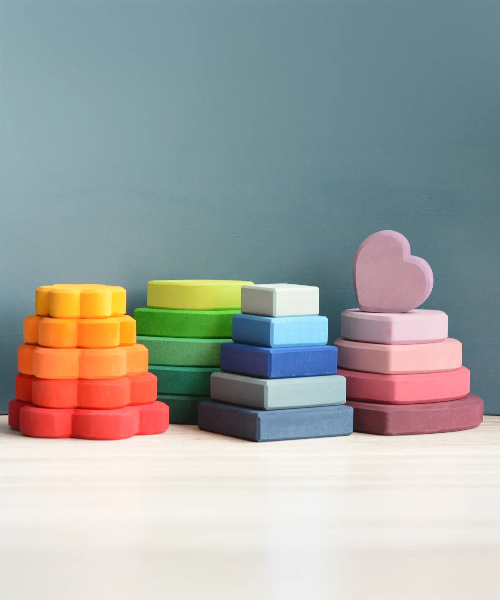 The flower, leaf, square and heart pieces of the Grimms stacking tower set stacked 