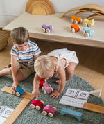 Children playing with the Grimm's Stacking Cars and natural building boards. Wooden toy cars that comes in a two back that can can be stacked on top of each other.
These Grimm's toys are part of a wide range of wooden toys available here at Babipur. 