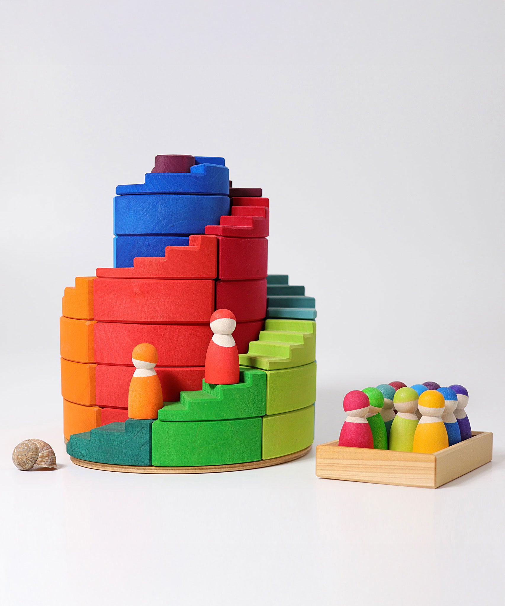 The Grimm's Counter-Rotating Stepped Spiral wooden block set pictured with the Grimm's rainbow friends.