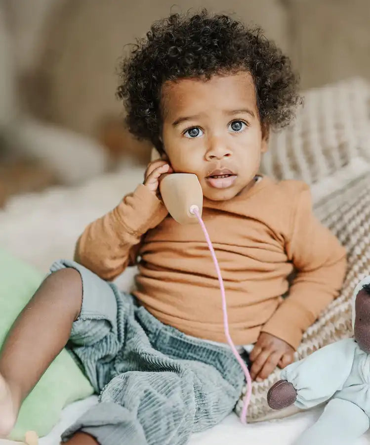 Child playing with the Grimm's wooden toy telephone. 