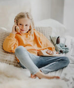Child playing with the Grimm's wooden toy telephone. 