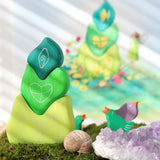 Grimm's tower leaves wooden stacking blocks set next to green and purple bird celebration ring figures.