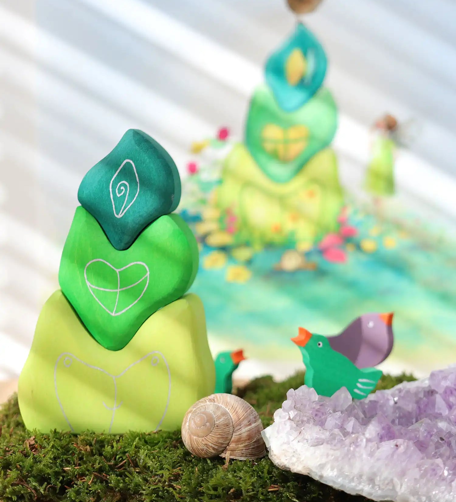 Grimm's tower leaves wooden stacking blocks set next to green and purple bird celebration ring figures.