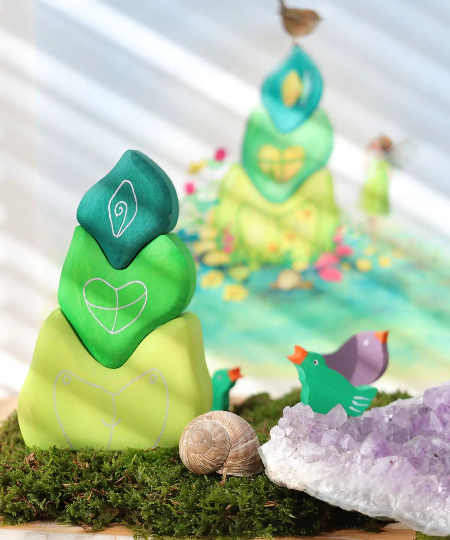 Grimm's tower leaves wooden stacking blocks set next to green and purple bird celebration ring figures.