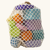 Grimm's tree slices wooden coloured building blocks in their netting storage bag. 