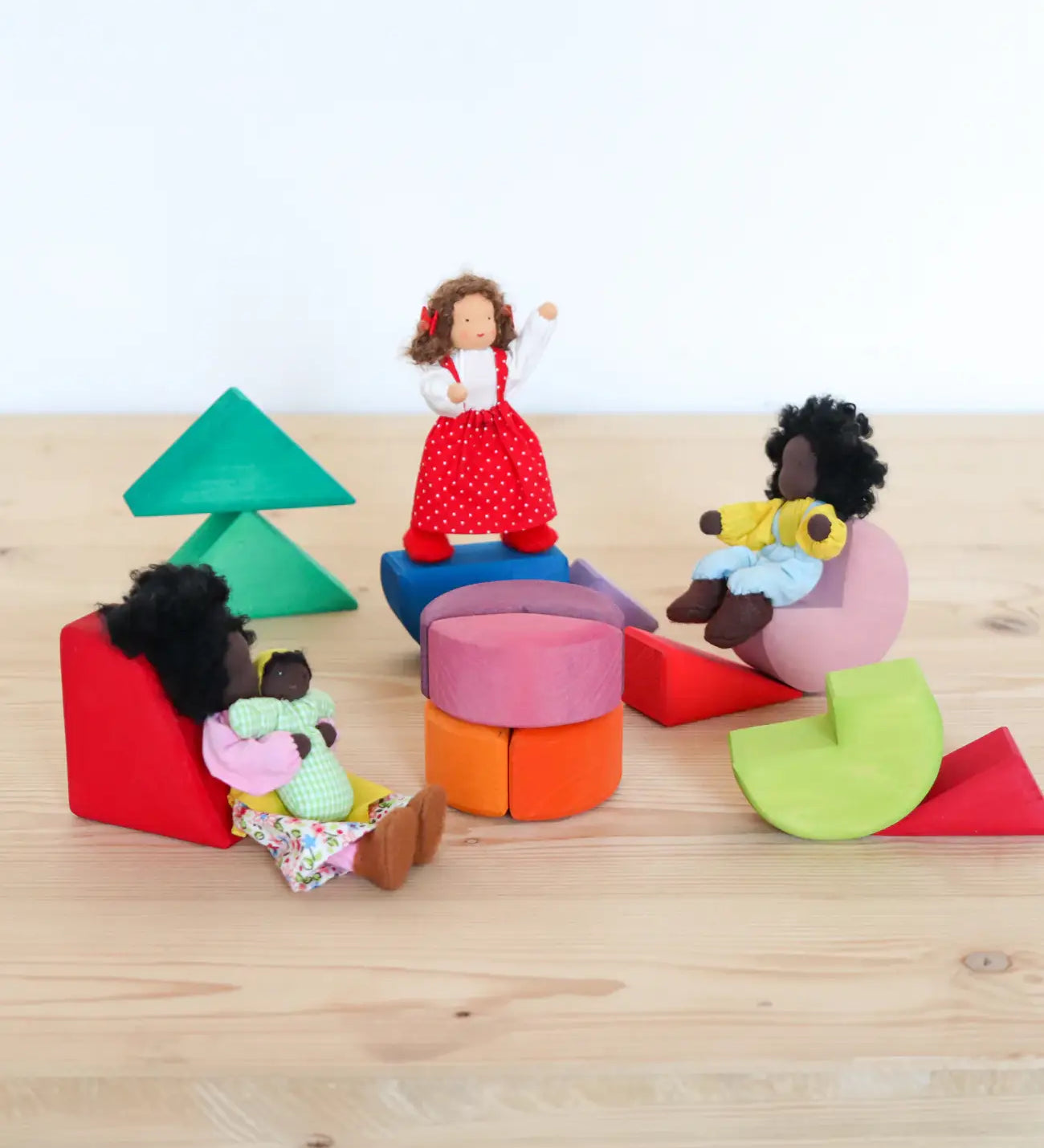 Grimms triangle, square and circle wooden blocks loose with waldorf dolls sitting on top