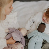 Children playing with a violet and aqua Grimms soft Waldorf dolls
